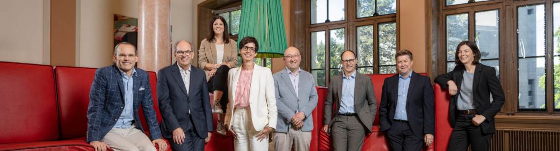  Die Mitglieder der Regierung vor einem riesigen roten Sofa